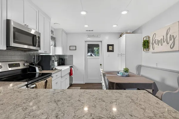 a kitchen with stainless steel appliances kitchen island granite countertop a sink and a stove