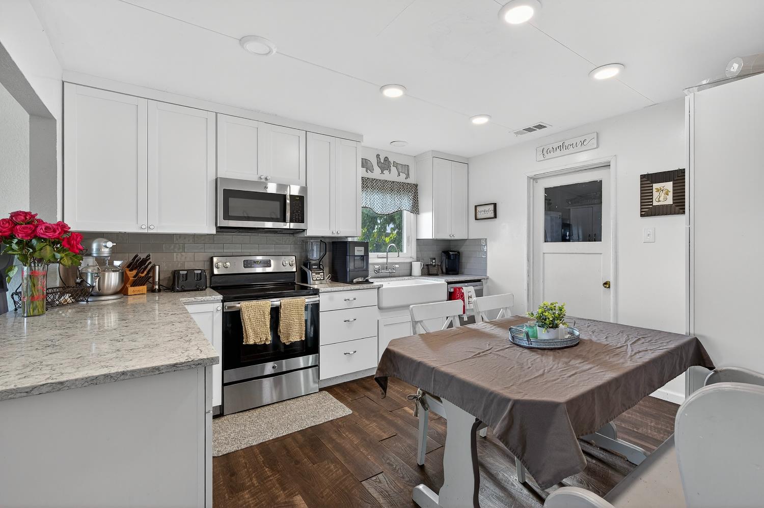 28015 Blossom Road Thornton, CA 95686 - Photo 6 of 34 a kitchen with stainless steel appliances granite countertop a stove top oven a sink dishwasher a dining table and chairs with wooden floor