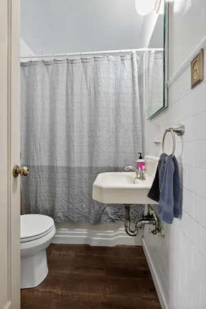 a bathroom with a sink a toilet and shower curtain