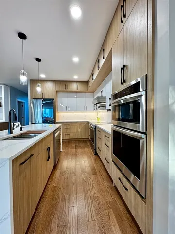 a large kitchen with stainless steel appliances granite countertop a stove and a sink
