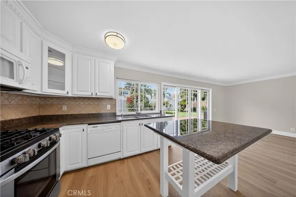 a kitchen with a stove a sink and a window