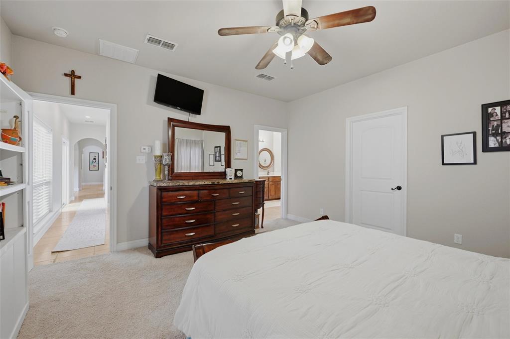 1959 Marlow Road Bells, TX 75414 - Photo 14 of 33 Bedroom featuring light colored carpet, arched walkways, ceiling fan, and connected bathroom