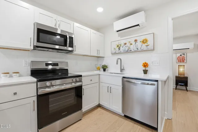 a kitchen with stainless steel appliances a stove a sink and a microwave