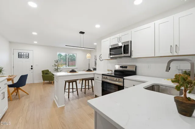 a kitchen with a table chairs microwave and cabinets