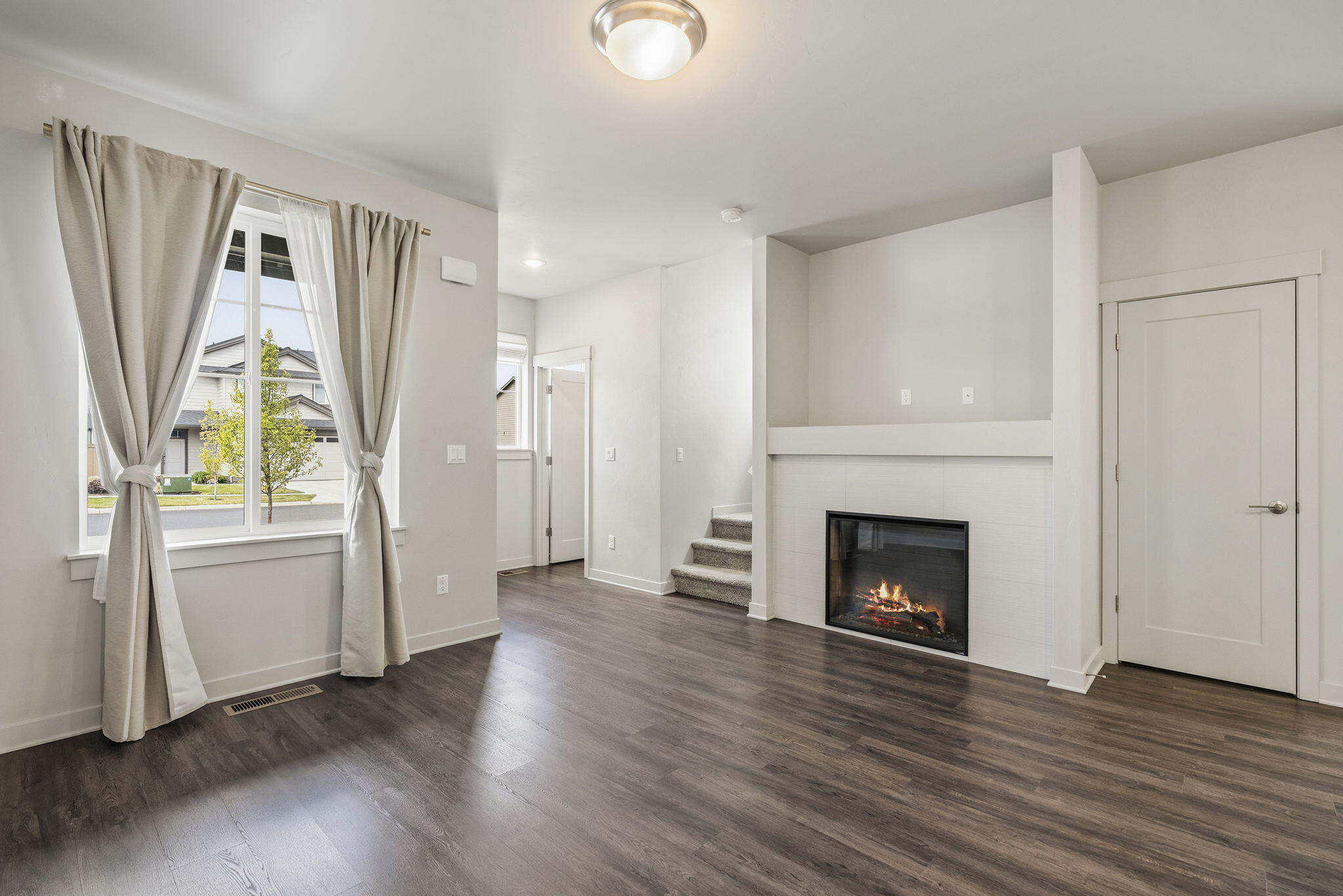 2366 Northeast Victor Place Bend, OR 97701 - Photo 4 of 31 an empty room with wooden floor fireplace and windows