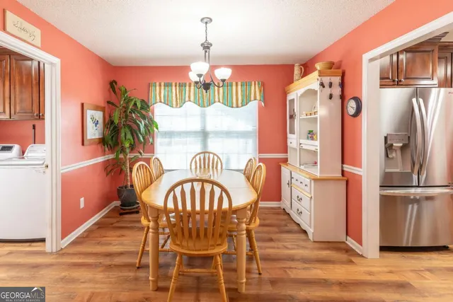 a dining room with furniture a chandelier and wooden floor