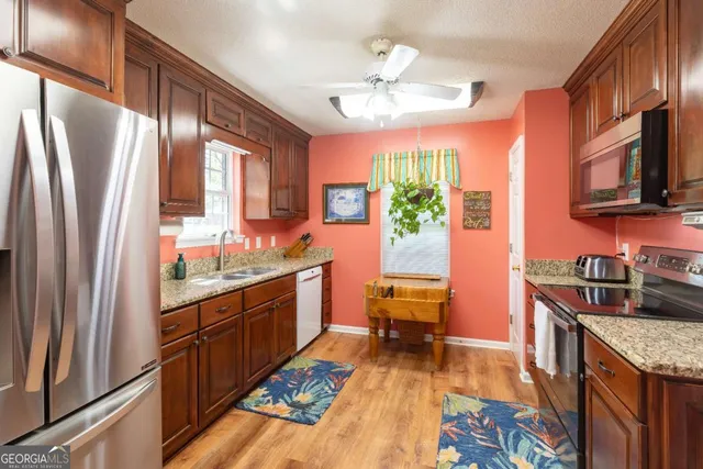 a kitchen with stainless steel appliances granite countertop a refrigerator and a sink