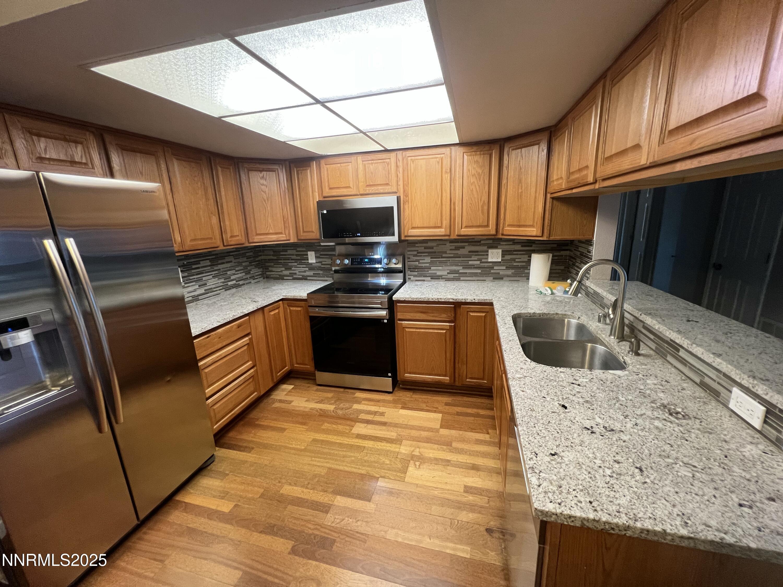 3095 Lakeside Drive, Unit 110 Reno, NV 89509 - Photo 8 of 49 a kitchen with stainless steel appliances granite countertop a sink a stove top oven a counter space and cabinets