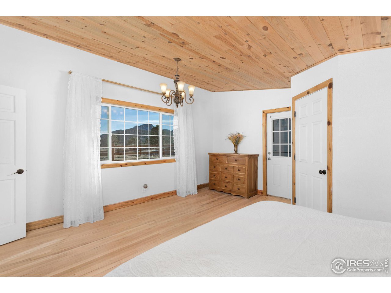 11725 Ranch Elsie Road Golden, CO 80403 - Photo 16 of 40 a big room with wooden floor and windows