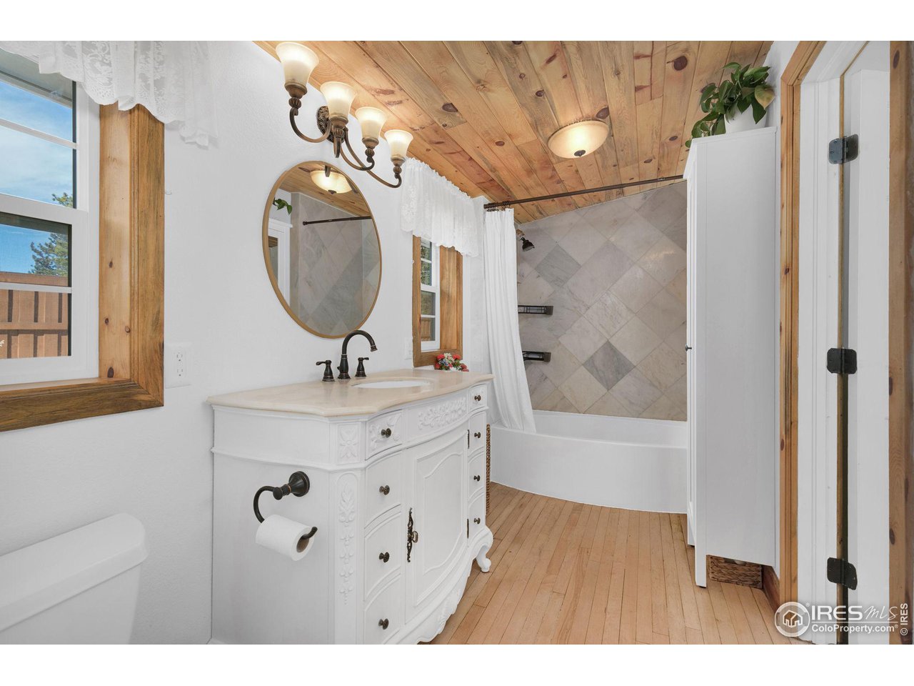 11725 Ranch Elsie Road Golden, CO 80403 - Photo 17 of 40 a bathroom with a sink a mirror a bathtub and shower
