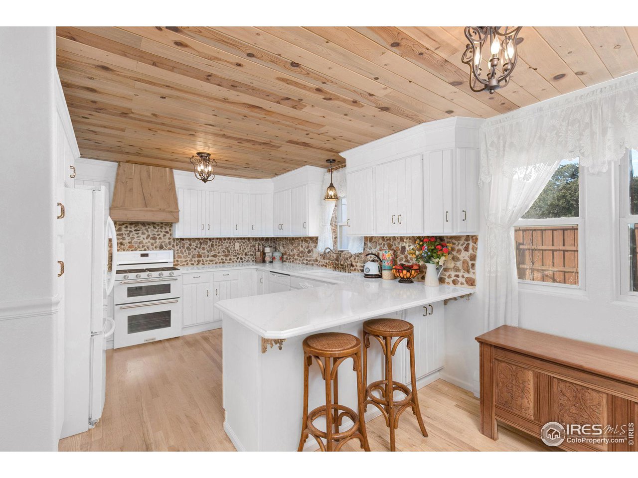 11725 Ranch Elsie Road Golden, CO 80403 - Photo 6 of 40 a kitchen with a refrigerator and white cabinets