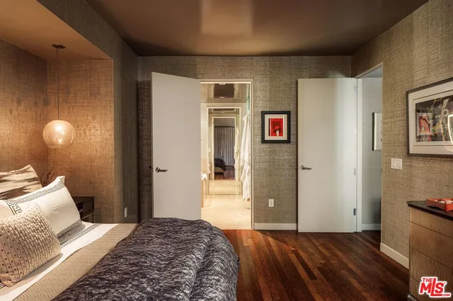 a bedroom with a bed and a lamp on dresser