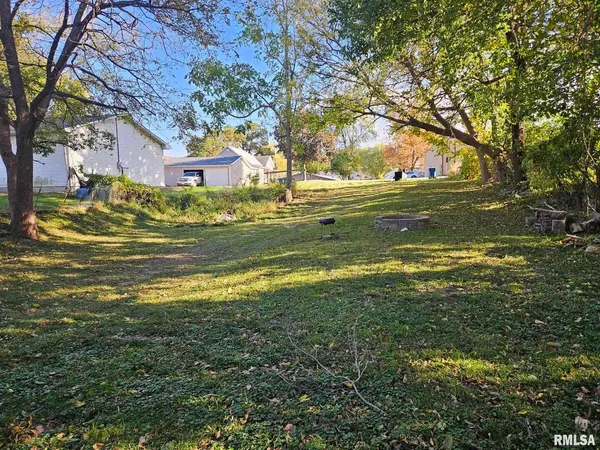 a view of swimming pool with large trees and wooden fence