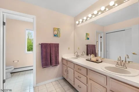 a spacious bathroom with a double vanity sink a mirror and a shower