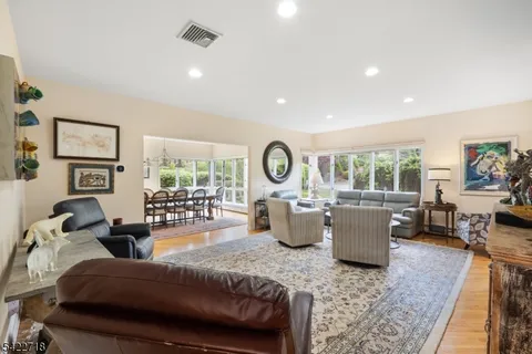 a living room with furniture a rug potted plant and a large window