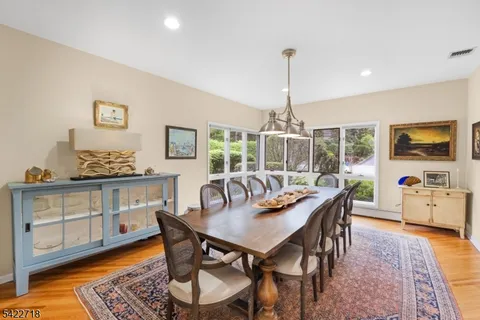 a dining room with furniture a chandelier and wooden floor