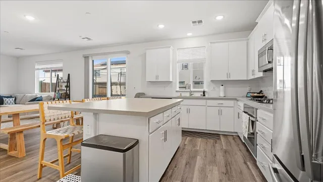 a kitchen with granite countertop a sink stove cabinets and refrigerator