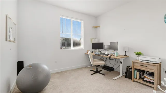 a view of a workspace with furniture and a window