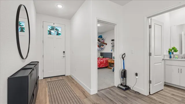 a view of a hallway with wooden floor and closet
