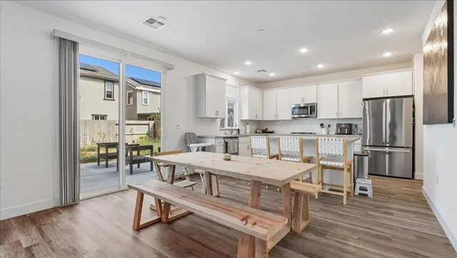 a kitchen with a table chairs refrigerator and cabinets