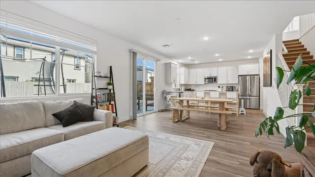 a living room with furniture and a dining table with kitchen view