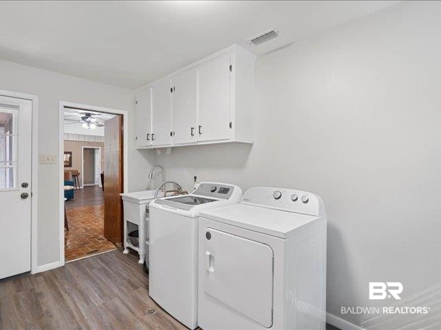 4650 Wiggins Lane Wilmer, AL 36587 - Photo 24 of 66 Washroom featuring washing machine and clothes dryer, cabinet space, light wood finished floors, and ceiling fan
