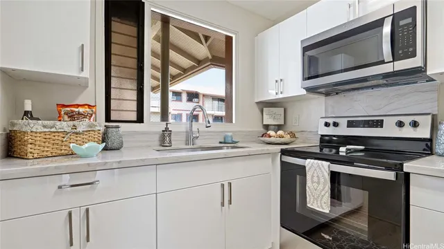 a kitchen with stainless steel appliances granite countertop a stove a sink and a microwave