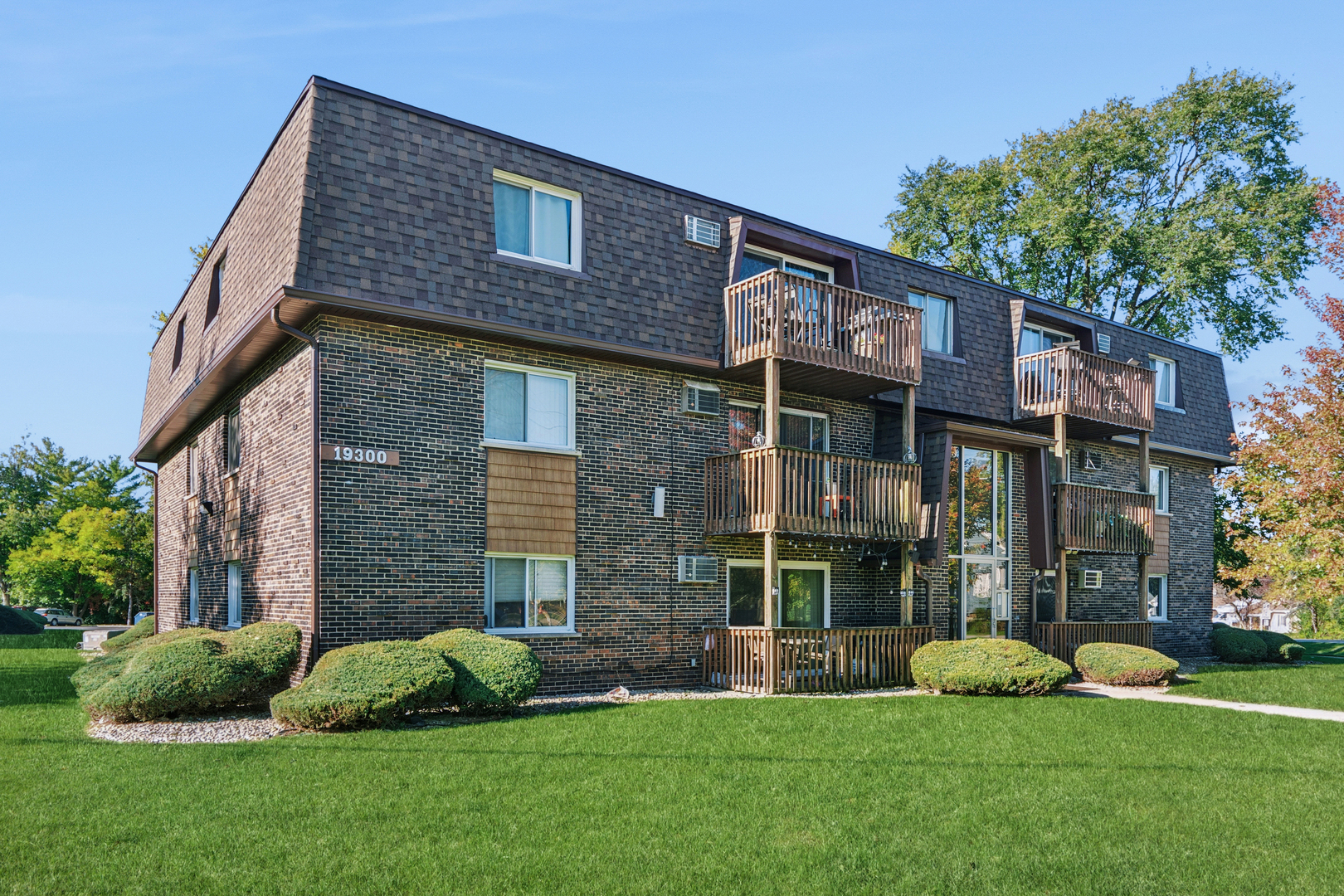 19300 Wolf Road, Unit 2 Mokena, IL 60448 - Photo 15 of 17 a brick house with a garden and plants