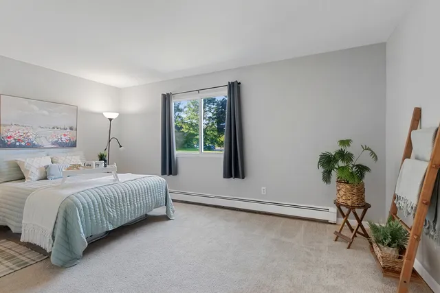 a bedroom with a bed and a potted plant