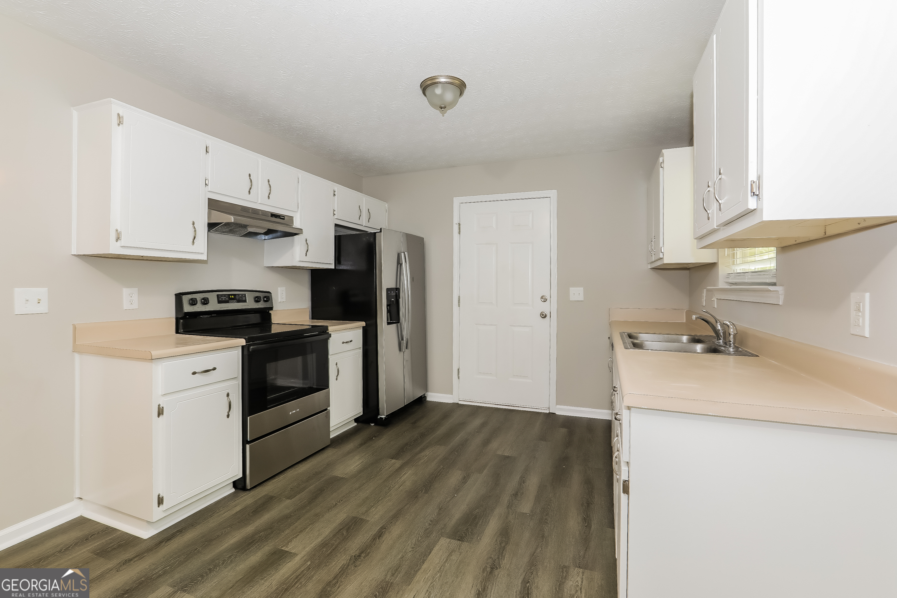 6530 River Hill Drive Flowery Branch, GA 30542 - Photo 3 of 14 a kitchen with a sink a stove and refrigerator