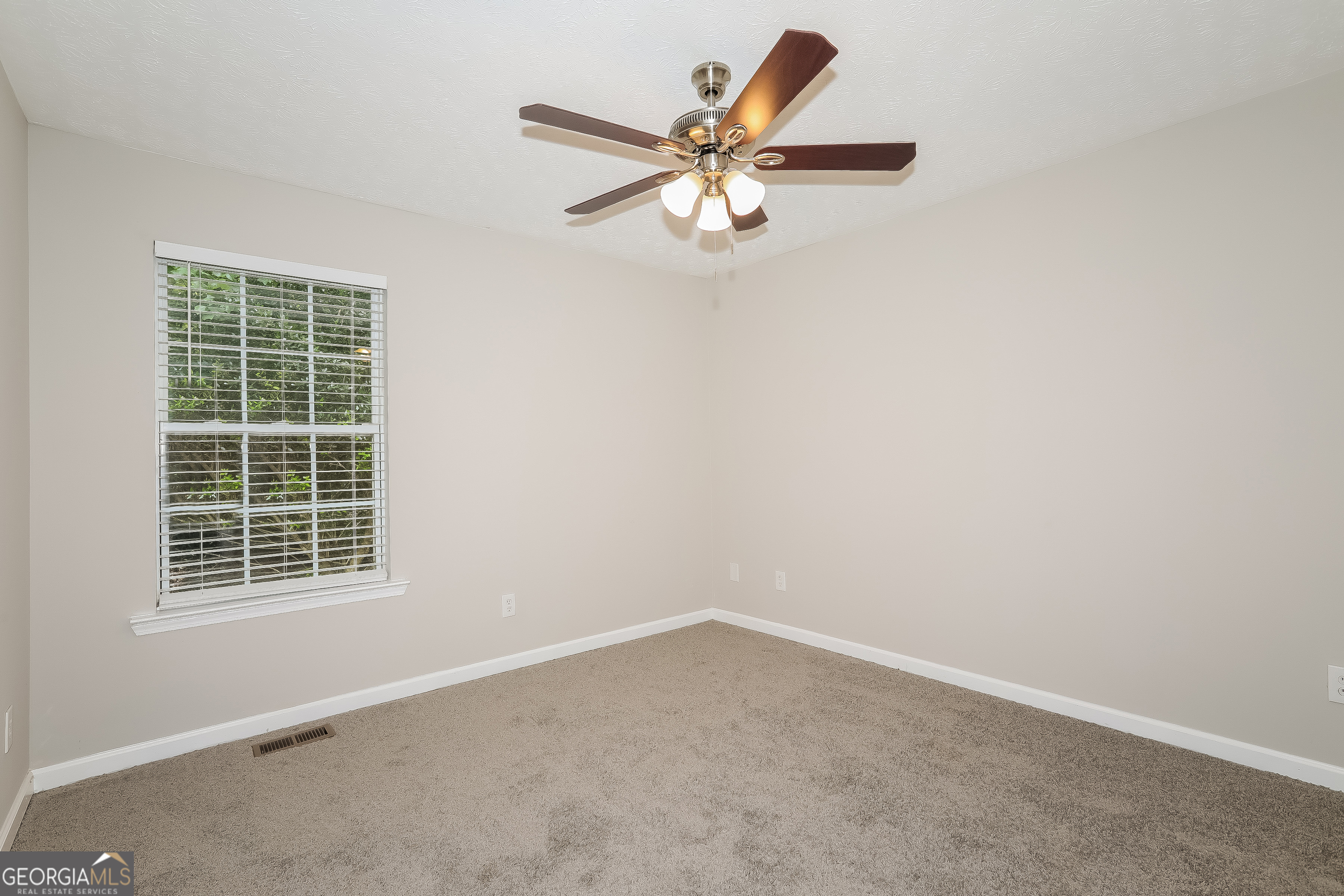 6530 River Hill Drive Flowery Branch, GA 30542 - Photo 6 of 14 an empty room with a window and a fan