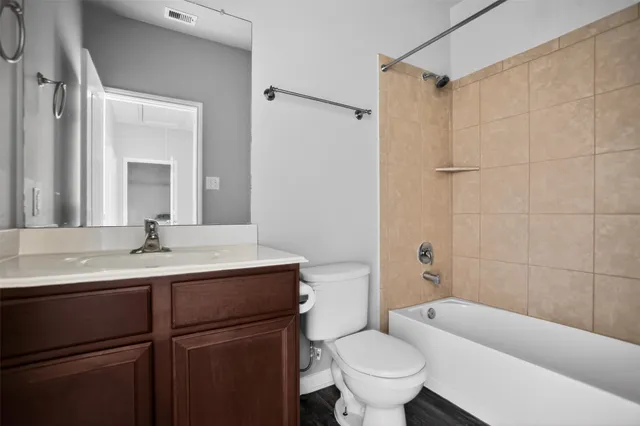 a bathroom with a sink toilet vanity and shower
