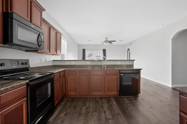 a kitchen with stainless steel appliances granite countertop a stove a sink and a microwave