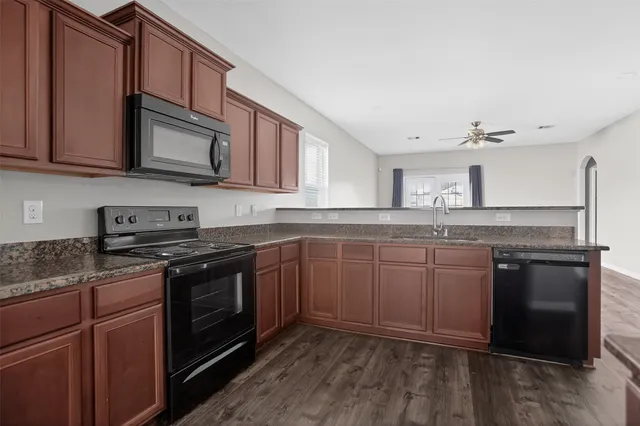 a kitchen with stainless steel appliances granite countertop a stove a sink and a microwave