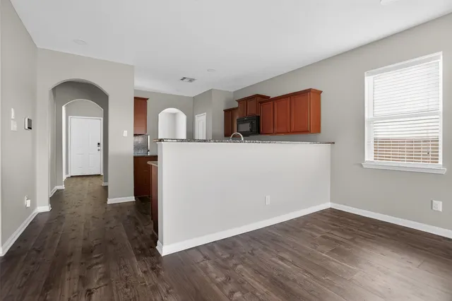 a view of kitchen with wooden floor electronic appliances and window