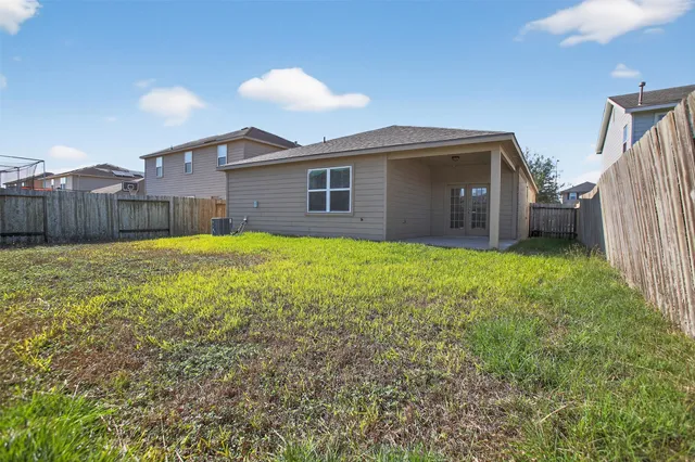 a view of a house with a yard and a large tree