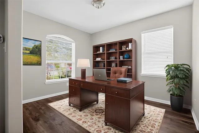 a view of a workspace with furniture and a window