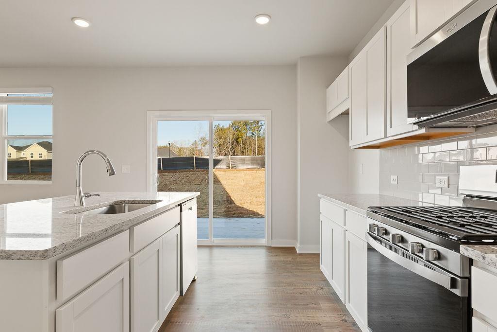 60 Poplar Blf Way Jefferson, GA 30549 - Photo 21 of 28 a kitchen with granite countertop a sink stove and cabinets