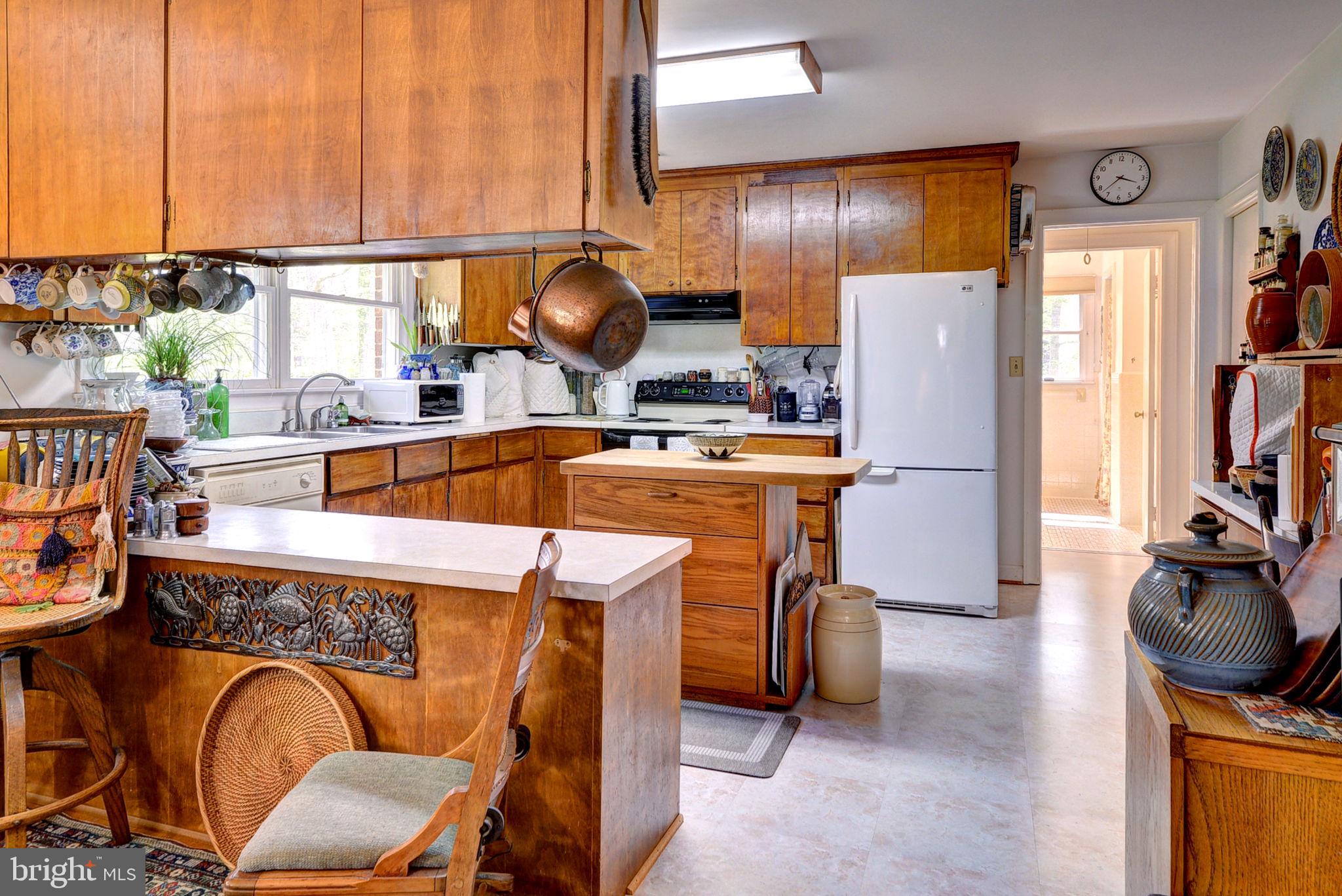 5556 Roanes Wharf Road Gloucester, VA 23061 - Photo 32 of 84 a kitchen with a refrigerator a stove and a dining table with wooden floor
