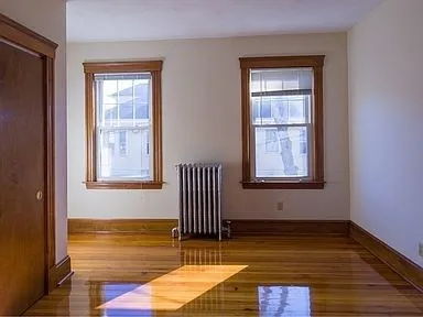 a view of a room with wooden floor and a window