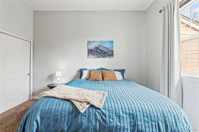 a bedroom with a bed and a painting on the wall
