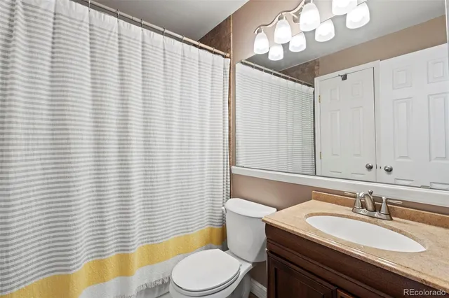 a bathroom with a sink a toilet a mirror and vanity