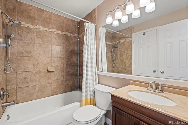 a bathroom with a sink a toilet a mirror a bathtub and shower