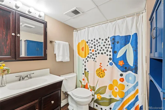 a bathroom with a sink mirror vanity and toilet