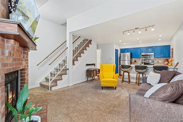 a living room with furniture kitchen view and a fireplace