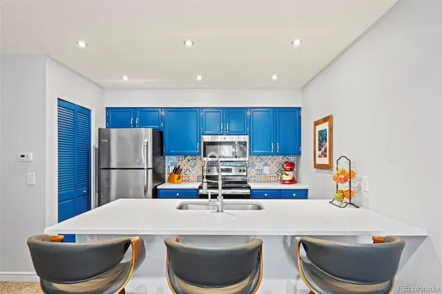 a kitchen with a dining table chairs and a refrigerator
