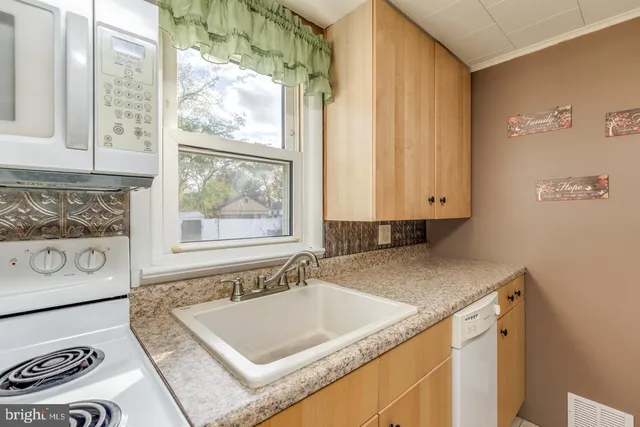 a bathroom with a granite countertop sink and a window