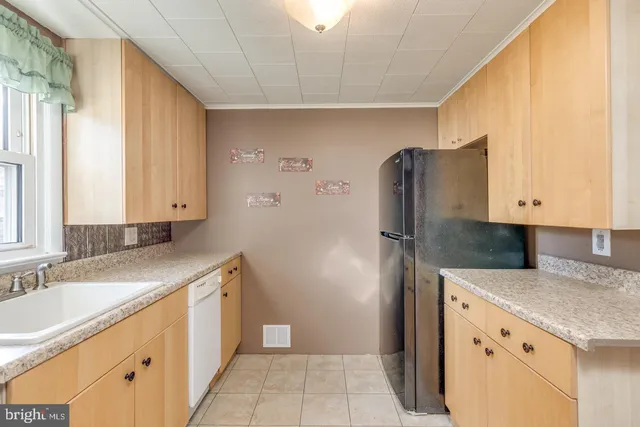 a kitchen with granite countertop a refrigerator and a sink