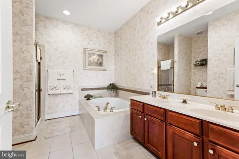 a spacious bathroom with a tub sink and mirror
