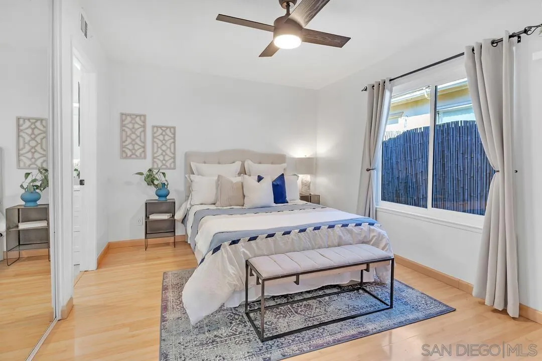 11021 Sagittarius Road San Diego, CA 92126 - Photo 15 of 28 a bedroom with a bed rug and wooden floor